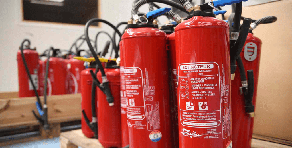 Batterie d'extincteurs portatifs rouges et équipements de protection contre l'incendie en entreprise.